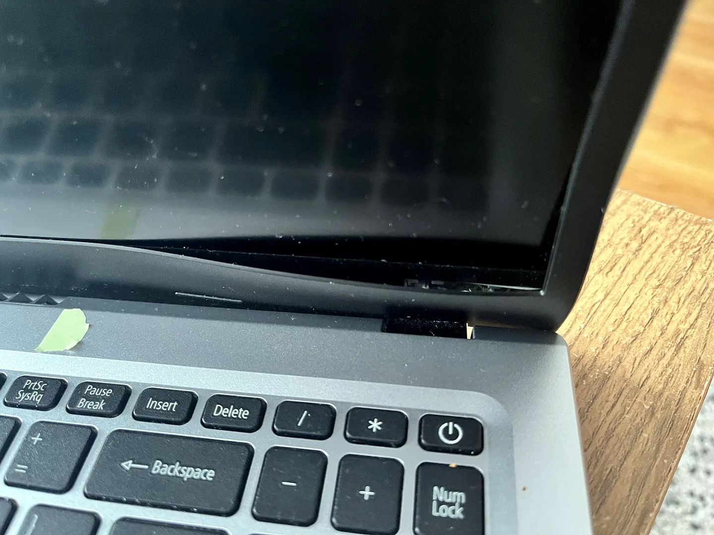 Damaged laptop hinge and casing inspected at the Birmingham repair workshop